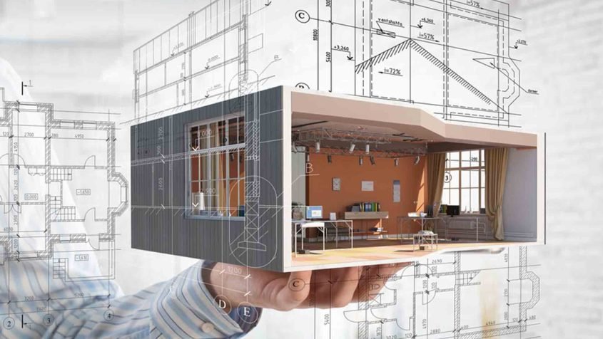 Beautiful Brunette Female Video Editor Works with Footage on Her Personal Computer with Big Display. She Works in a Cool Office Loft. Other Male Creative Colleague Walks in the Background.